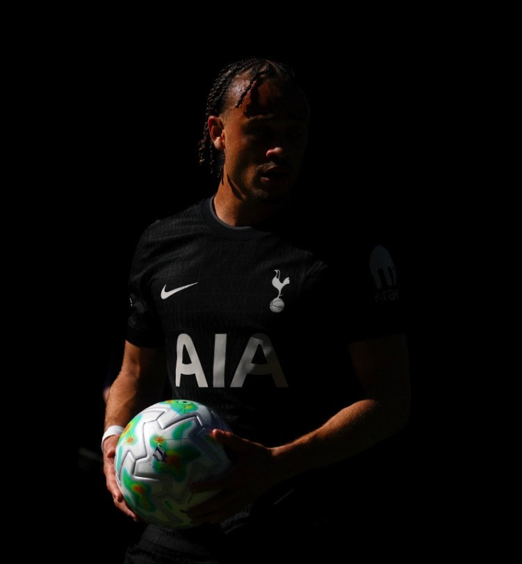 Xavi Simons in the dark Tottenham Hotspur kit, holding a match ball
